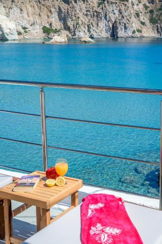 a table with a bowl of fruit and a glass of orange juice at Giasemi Boathouse in Firopótamos