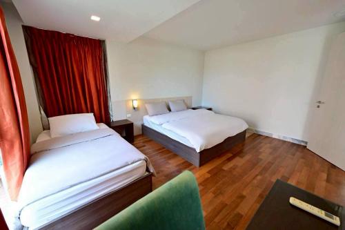 une chambre d'hôtel avec deux lits et une chaise dans l'établissement Fiscus Villa 3 bedrooms with private pool., à Pattaya (sud)