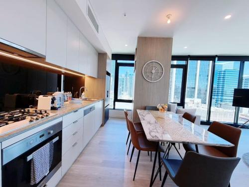 a kitchen with a table and some chairs and some windows at Stylish suites with City-view & Balcony in York&George in Sydney