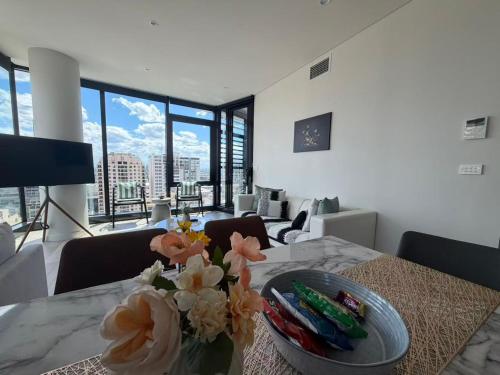 a dining room table with a vase of flowers on it at Stylish suites with City-view & Balcony in York&George in Sydney