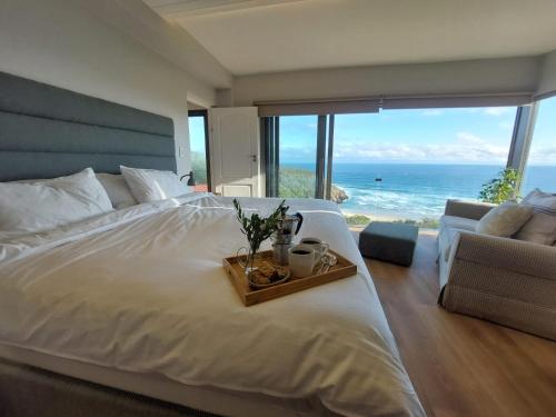 una camera da letto con un letto grande con vista sull'oceano di Salt & Soul a Herolds Bay