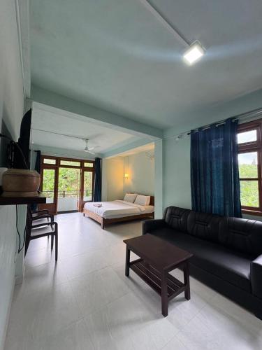 a living room with a couch and a bed at Riwai Root Bridge homestay in Mawlynnong