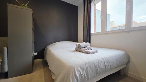 Un dormitorio pequeño con una cama con toallas. en Intimissime, en Dunkerque