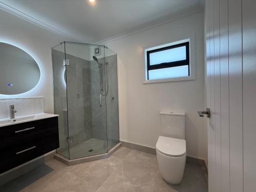 ein Badezimmer mit Dusche, Toilette und Waschbecken in der Unterkunft Central Apartments in Rotorua