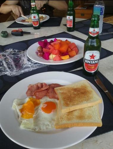 twee borden met ontbijt op tafel met drankjes bij Tanjung Sari Inn in Nusa Dua