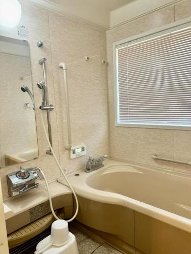 a bathroom with a bath tub and a shower at 桜Sakura in Omachi