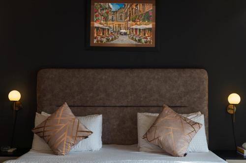 uma cama com duas almofadas e um quadro por cima em Gold Crest Grand Apartments City View -DHA Phase 4 Lahore em Lahore