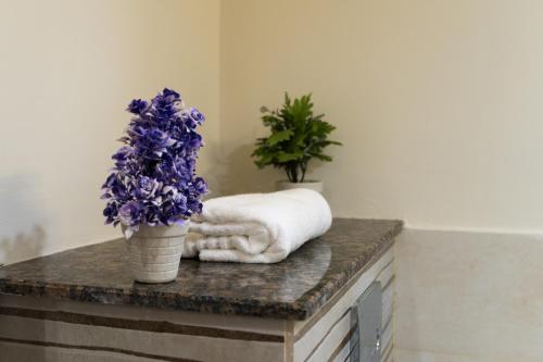 uma mesa com uma toalha e flores roxas sobre ela em Gold Crest Grand Apartments City View -DHA Phase 4 Lahore em Lahore