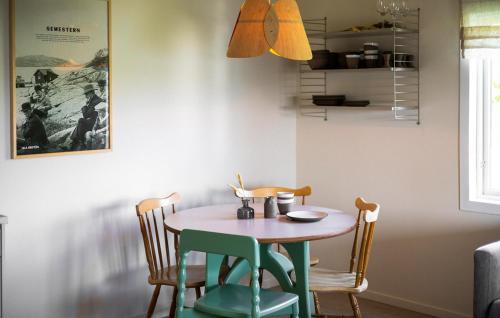 a dining room table with four chairs and a table and a lamp at Lovely Home In Myggenäs With Sauna in Höviksnäs