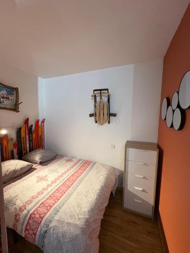 a bedroom with a bed and a dresser in it at Chamrousse Residence le Balcon de Recoin - Au pied des pistes in Chamrousse