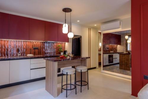 een keuken met paarse kasten en barkrukken bij Mavili Urban Elegance in Bendevís