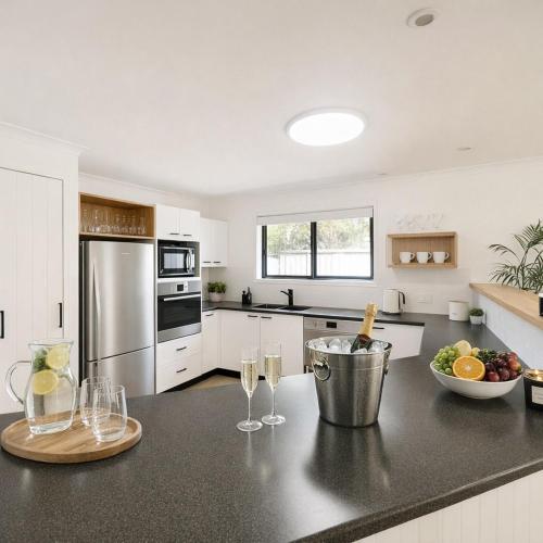 a kitchen with a counter with wine glasses on it at LUXE Tropical oasis, magnesium pool, 4bed in Noosa Heads