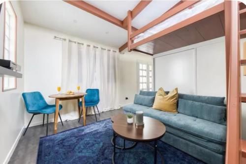 een woonkamer met een blauwe bank en een tafel bij Studio Cosy RerA bord de Marne in Nogent-sur-Marne