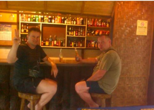 two men sitting at a bar in a bar at Star Lotus Guesthouse in Sampong