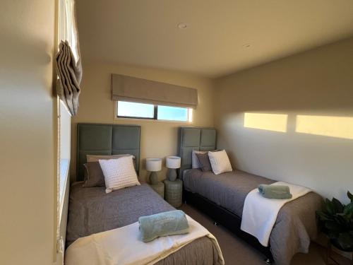 a bedroom with two beds and a window at Golden Ridge Retreat in Otorohanga