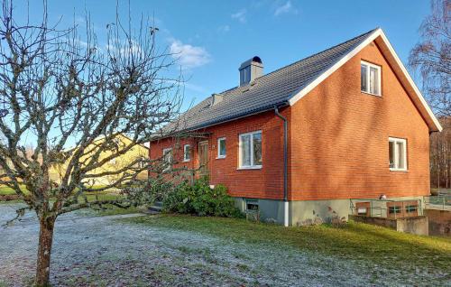 a red brick house with a tree in front of it at Nice Home In Bolmsö With Lake View in Bolmsö