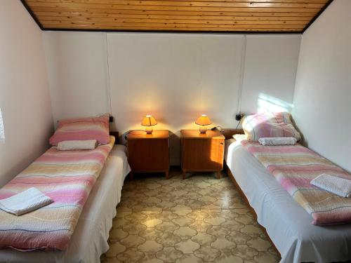 two beds in a room with two lamps on them at Dombi-Lak in Tiszakécske