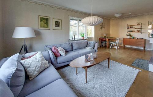 a living room with a blue couch and a table at Nice Home In Bolmsö With Lake View in Bolmsö