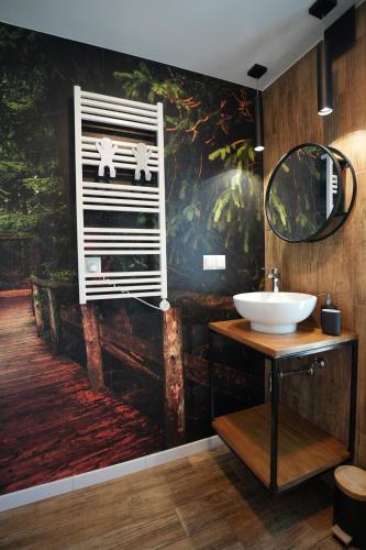 a bathroom with a sink and a painting on the wall at Brzuchem do góry in Chocieszow
