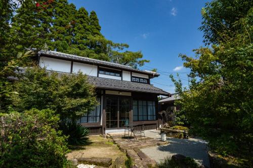 a japanese house with a garden and trees at PAAK Hotel in Nichinan
