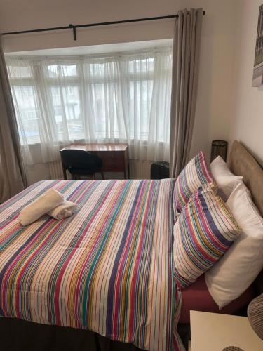 a bedroom with a bed with a colorful blanket at Standard Double Room near OVO Wembley Stadium in London