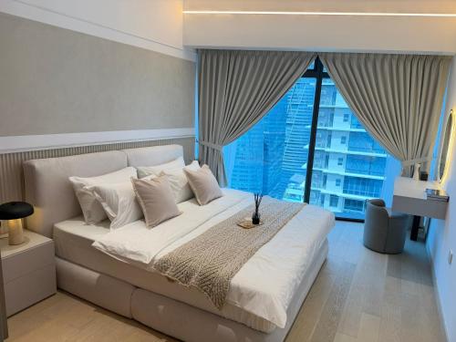 a bedroom with a white bed with a large window at Eaton Suites KLCC by Perkasa Ikon in Kuala Lumpur