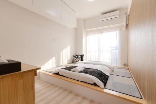 a bedroom with a large bed with a window at 匯金中葛西ビル in Tokyo