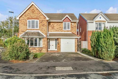 a brick house with a white garage at Spacious 4 Bedroom Warrington House with Free Parking Perfect for Contractors, Families and Business Guests in Great Sankey