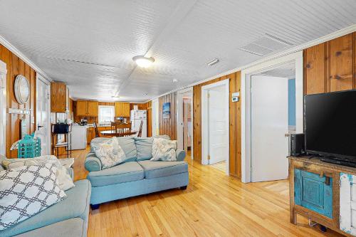a living room with a blue couch and a tv at Cozy Corner in Folly Beach