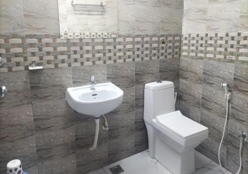 un baño con inodoro y lavabo en All Seasons Guest House, en Trivandrum
