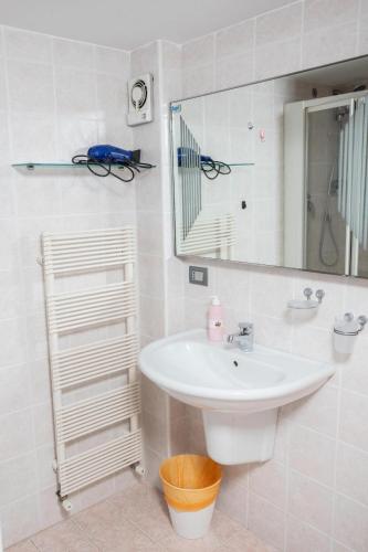 a white bathroom with a sink and a mirror at La finestra sulla piazza in Pisticci