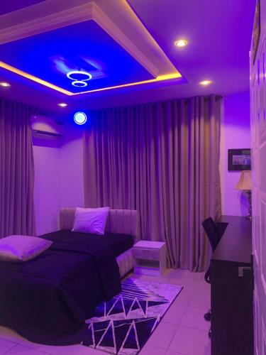 a bedroom with a bed and a purple ceiling at Ozin Retreat And Wellness Home in Ikeja