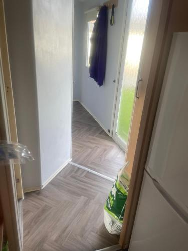 a hallway with a door open to a room with wood floors at Gemini in Heysham