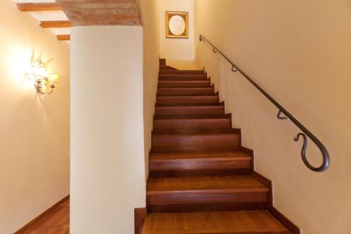 a stairway with wooden floors and a white wall at Hotel Scilla in Sovana