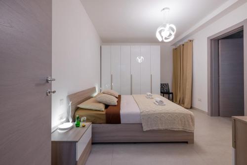 a bedroom with a bed and a chandelier at Elmswater court in St. Paul's Bay