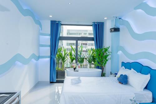a bedroom with a large bed and a bath tub at Ori Home in Ho Chi Minh City