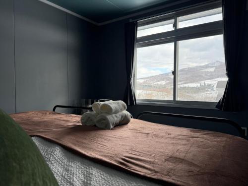 a bedroom with a bed with a large window at Rusutsu Ski Stay111 in Rusutsu