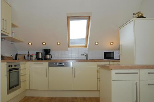 a kitchen with white cabinets and a window at Gabis-ferienwohnung in Schwörsheim