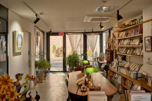 ソウルにあるSpace in Blackstoneの本棚とランプ付きテーブルが備わる部屋