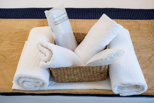a basket filled with towels and a bottle of bleach at Ifigeneia Premium Villa in Limenaria