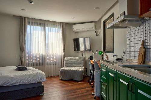 ソウルにあるSpace in Blackstoneのシンク付きのキッチンとベッドが備わった部屋