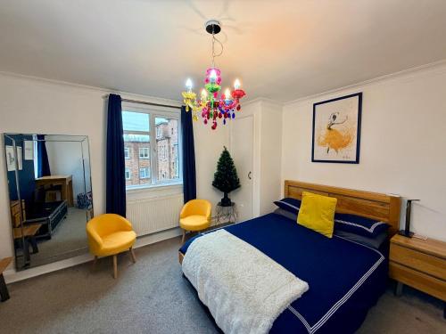 a bedroom with a blue bed and a chandelier at Modern Central Apartment with Free Parking in Southampton