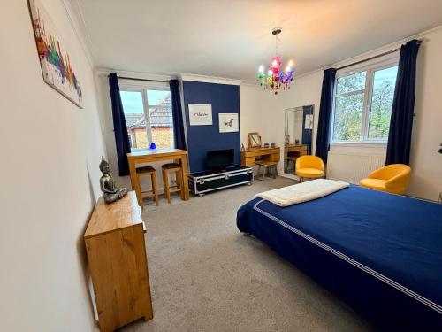 - une chambre avec un lit bleu et un bureau dans l'établissement Stylish & Modern Central Studio Apartment Free parking, à Southampton