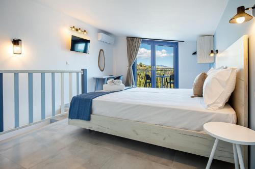 a bedroom with a bed and a balcony at Ifigeneia Premium Villa in Limenaria