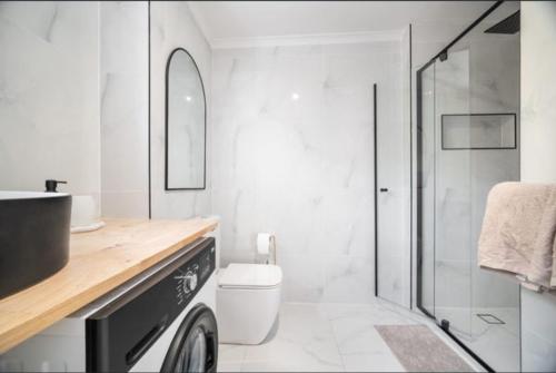 Boutique home in the heart of Surfers Paradise في غولد كوست: حمام مزود بمرحاض ودش زجاجي