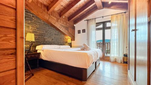 a bedroom with a bed and a brick wall at Cal Fontcitrana, casa de montaña in Llivia