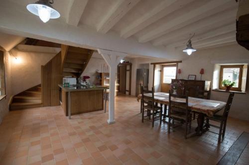 Una cocina y un comedor con mesa y sillas. en La Grande Métairie Notz Marafin, en Paulnay