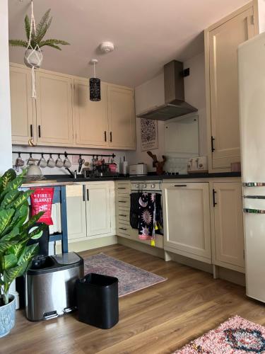 a kitchen with white cabinets and a refrigerator at The Cwtch in Ludlow