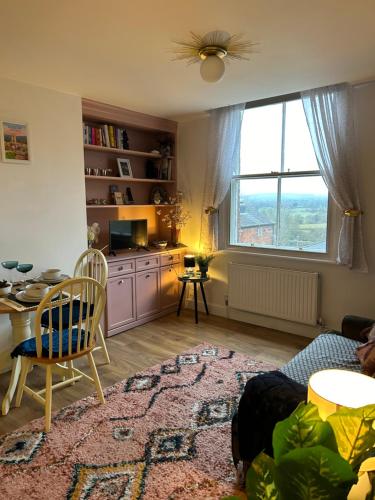 a living room with a table and chairs and a window at The Cwtch in Ludlow