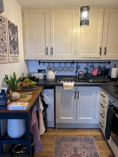 a kitchen with white cabinets and a sink at The Cwtch in Ludlow
